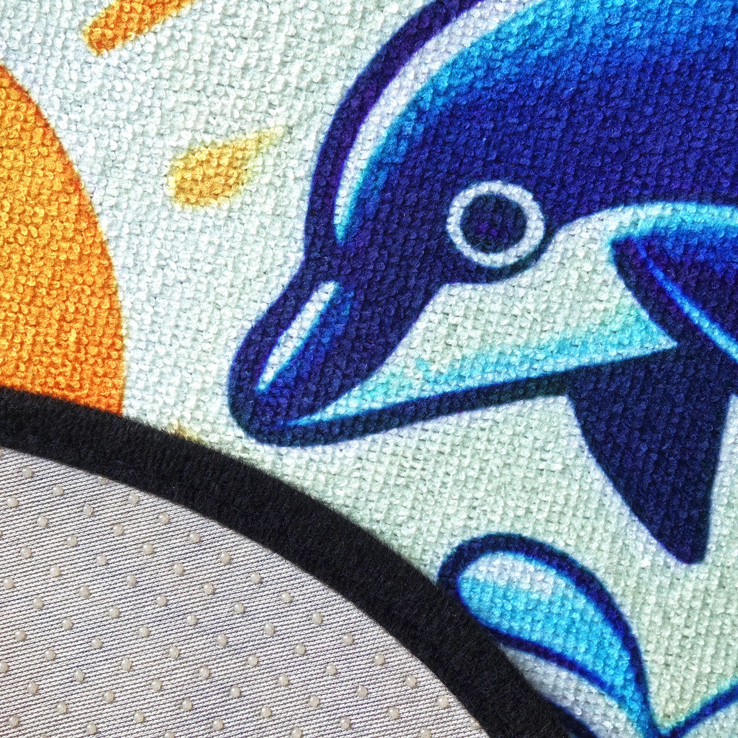 Close-up of a blue dolphin design on fabric with a sunset background, with close up of fabric waterproof membrane